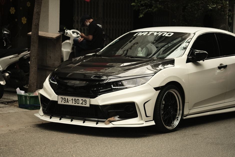 A sleek, custom-modified white sports car parked on an urban street. Perfect for enthusiasts.